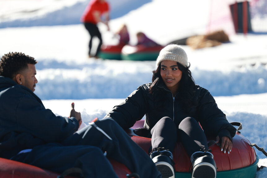 Jeremiah Brown and Andreina Santos on floting tubes on the snow.