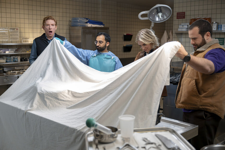 Ned (Domhnall Gleeson), Mare (Chelsea Frei), and Travis (Eric Rahill) in a medical room in The Paper Season 2 Episode 1.