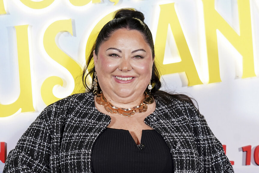 Stella Pecollo smiling in front of a step and repeat.