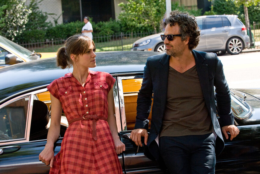 Keira Knightley as Greta and Mark Ruffalo as Dan sit on a car in the movie Begin Again (2013)