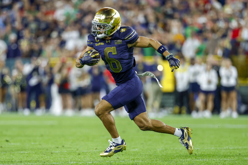 Jordan Faison, #6 of the Notre Dame Fighting Irish, runs with the ball during a game.