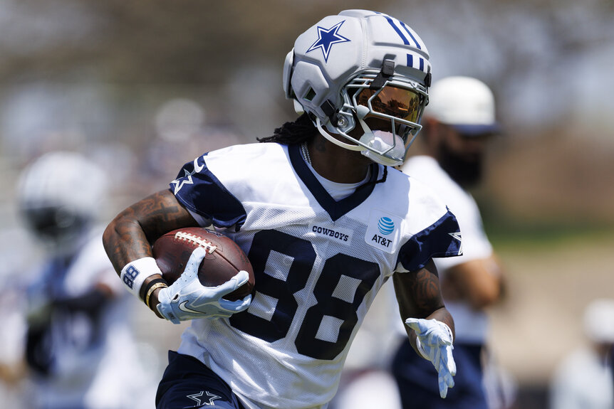 Ceedee Lamb, #88 of the Dallas Cowboys, running with a football during training camp.