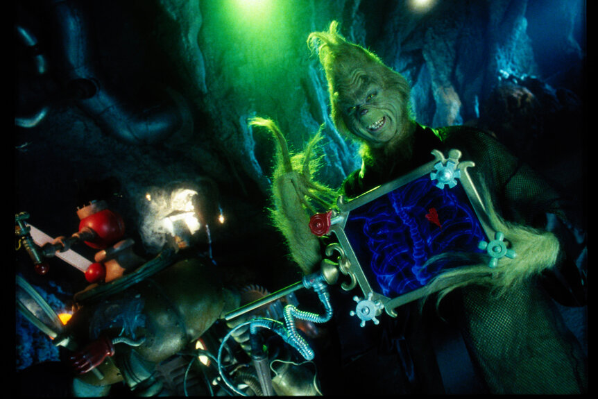 The Grinch holding up a x-ray machine that shows his ribs and small heart.