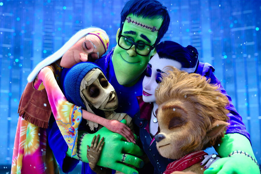 The Wishbone family embracing each other in front of a blue backdrop during The Monster Family (2017)