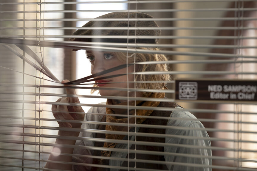 Mare Pritti (Chelsea Frei) looking through window blinds in The Paper Season 2.
