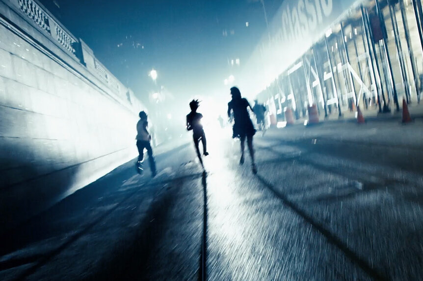 People running through the streets at night in the film Cloverfield (2008).