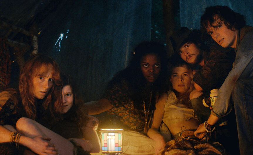 Cast gathered round a fire on Crystal Lake Season 1.