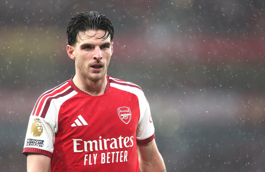 Declan Rice in an Arsenal jersey during a rainy Premier League match against Everton at Emirates Stadium.