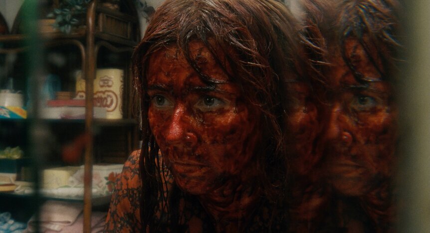 Linda Cardellini with her face covered in blood.